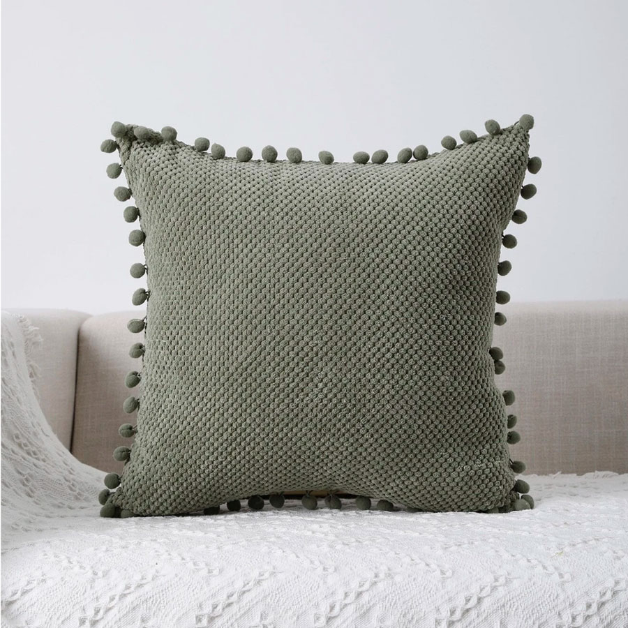Yesrentals-Kussen-donker-groen-met-pompoms Dit kussen eva groen is een tof kussen met een stippen patroon